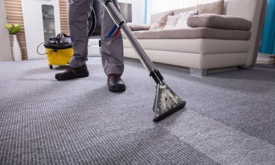 person cleaning carpet with vacuum cleaner